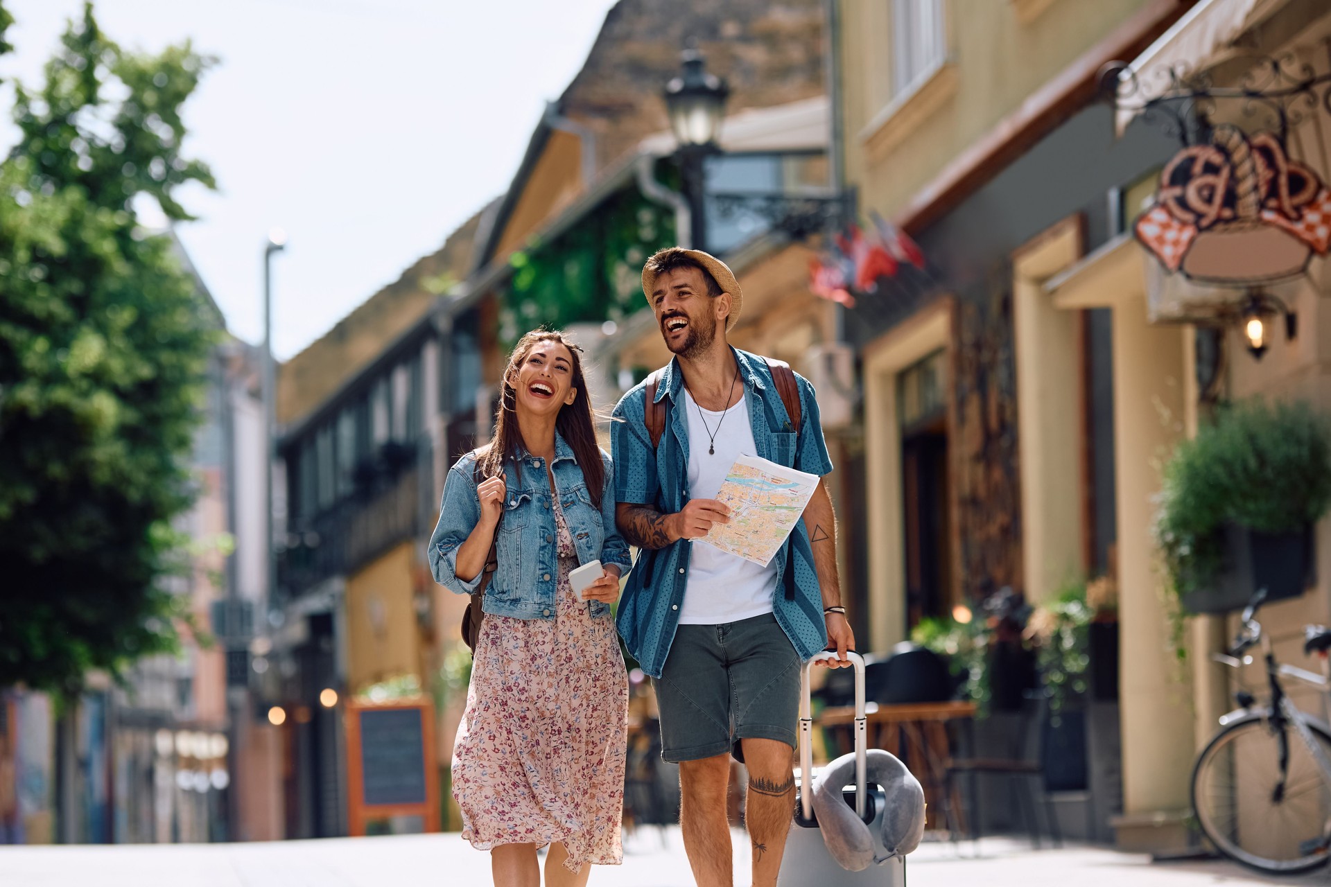 Cheerful couple of tourists walking in the city while traveling together.